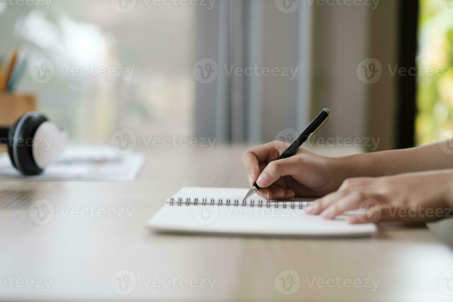 Close up of woman studying, reading book, and taking notes. photo