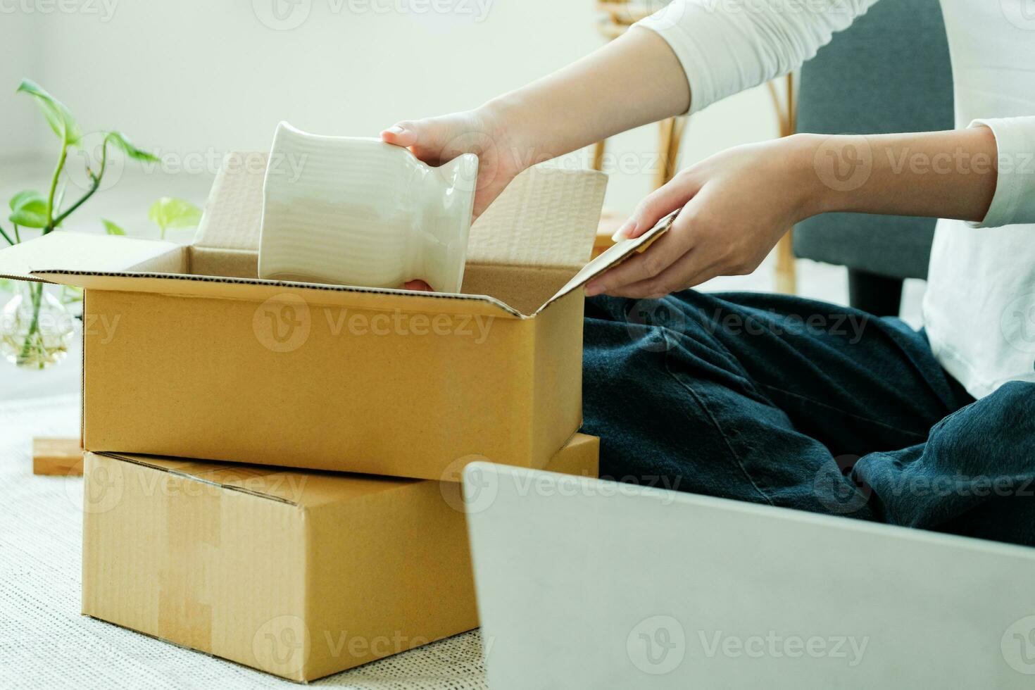 Asian female owner folding a product and packing in a cardboard parcel box. photo