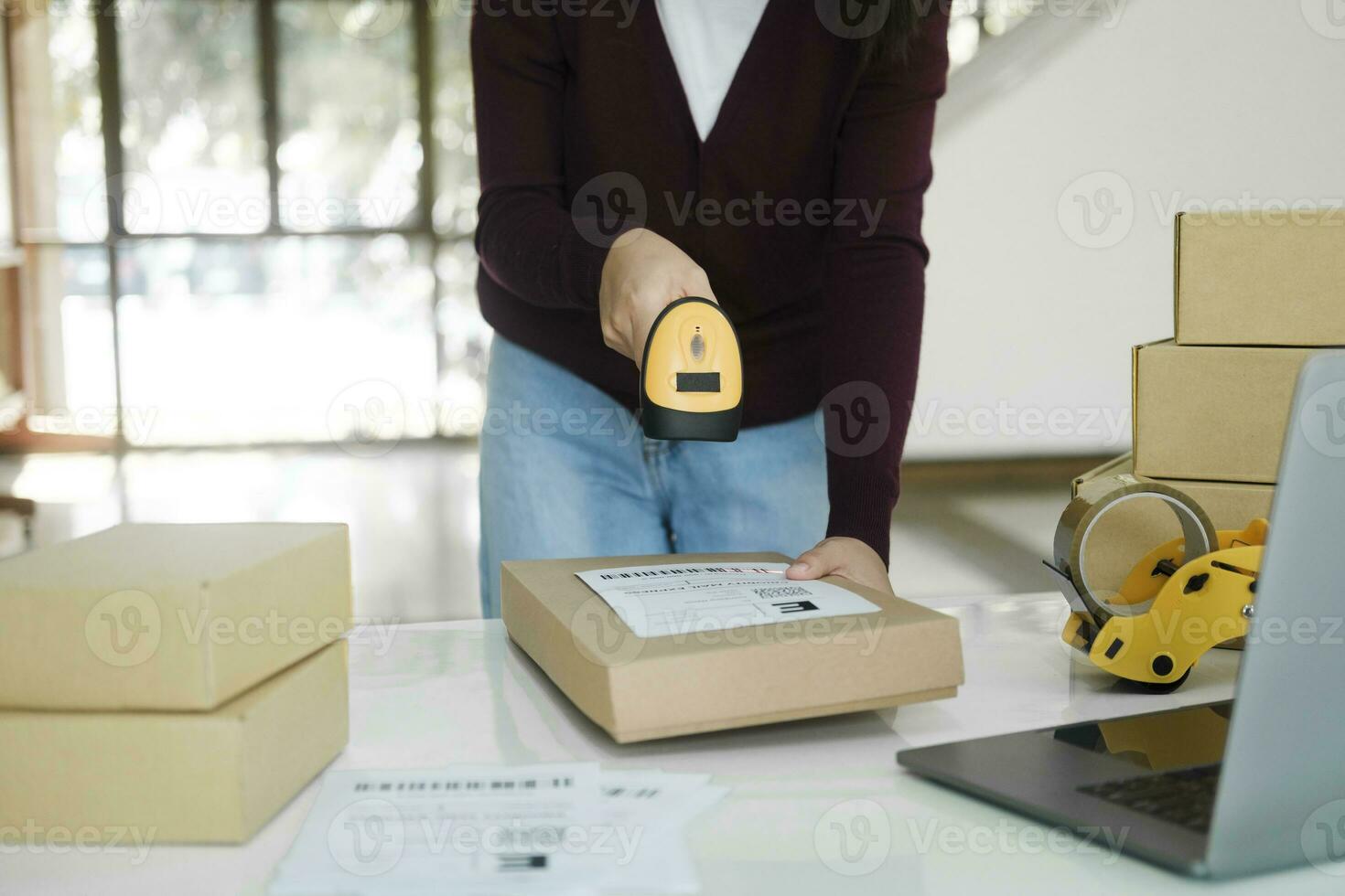 Female online business owner scan shipping label on parcel. photo