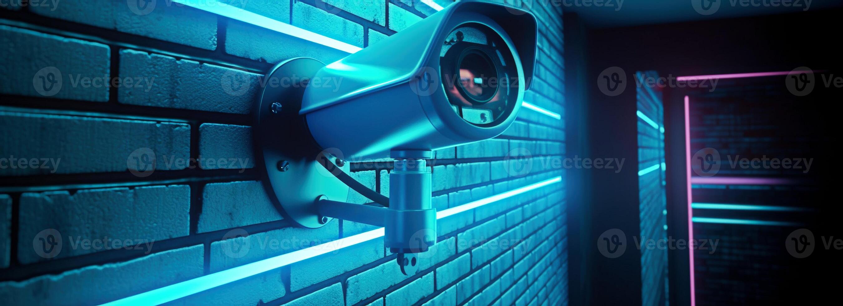 Modern CCTV camera on a wall. A neon light night cityscape background. Concept of surveillance and monitoring. Toned image double exposure mock up. photo