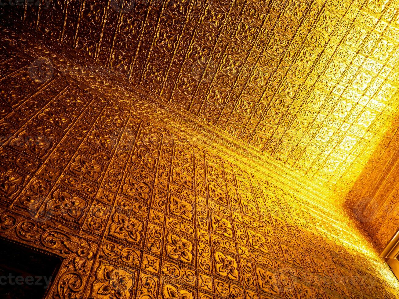 Burmese art pattern motifs decorative design on the golden walls of the rooms in the temple photo