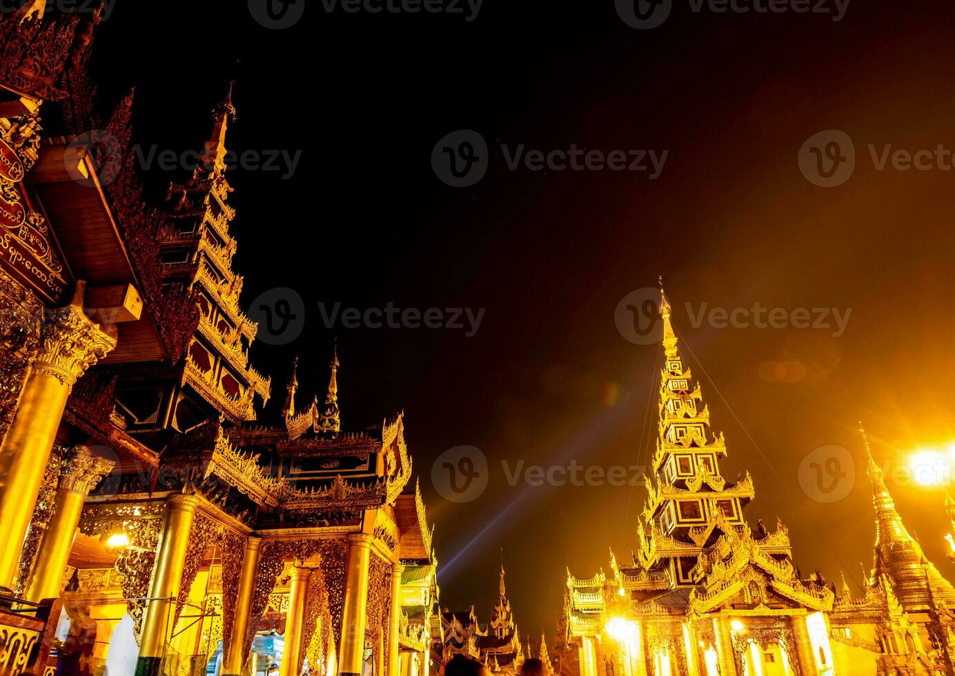 The golden pagodas and mondops are illuminated in the light of the night photo