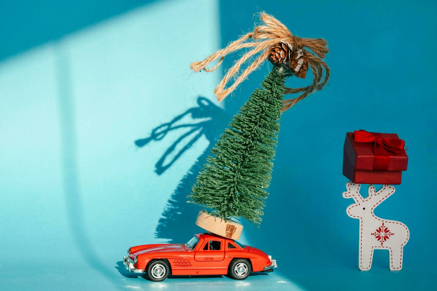 krasnodar, Rusia - diciembre 10, 2019 rojo juguete coche con un Navidad árbol en el techo, blanco antecedentes. Copiar espacio . concepto nuevo año. foto