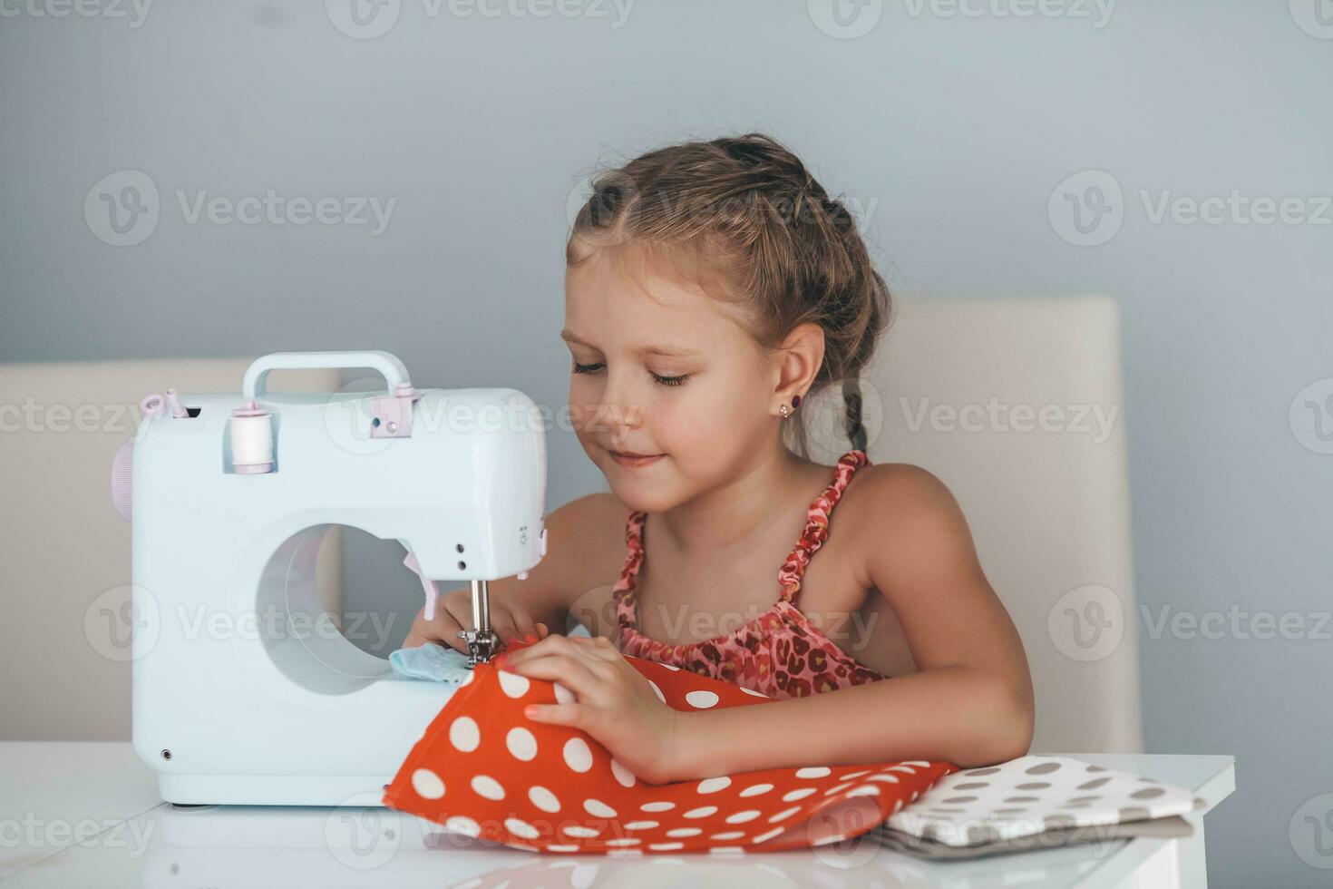 7 years old child studying work with a modern sewing machine. Hobby. photo