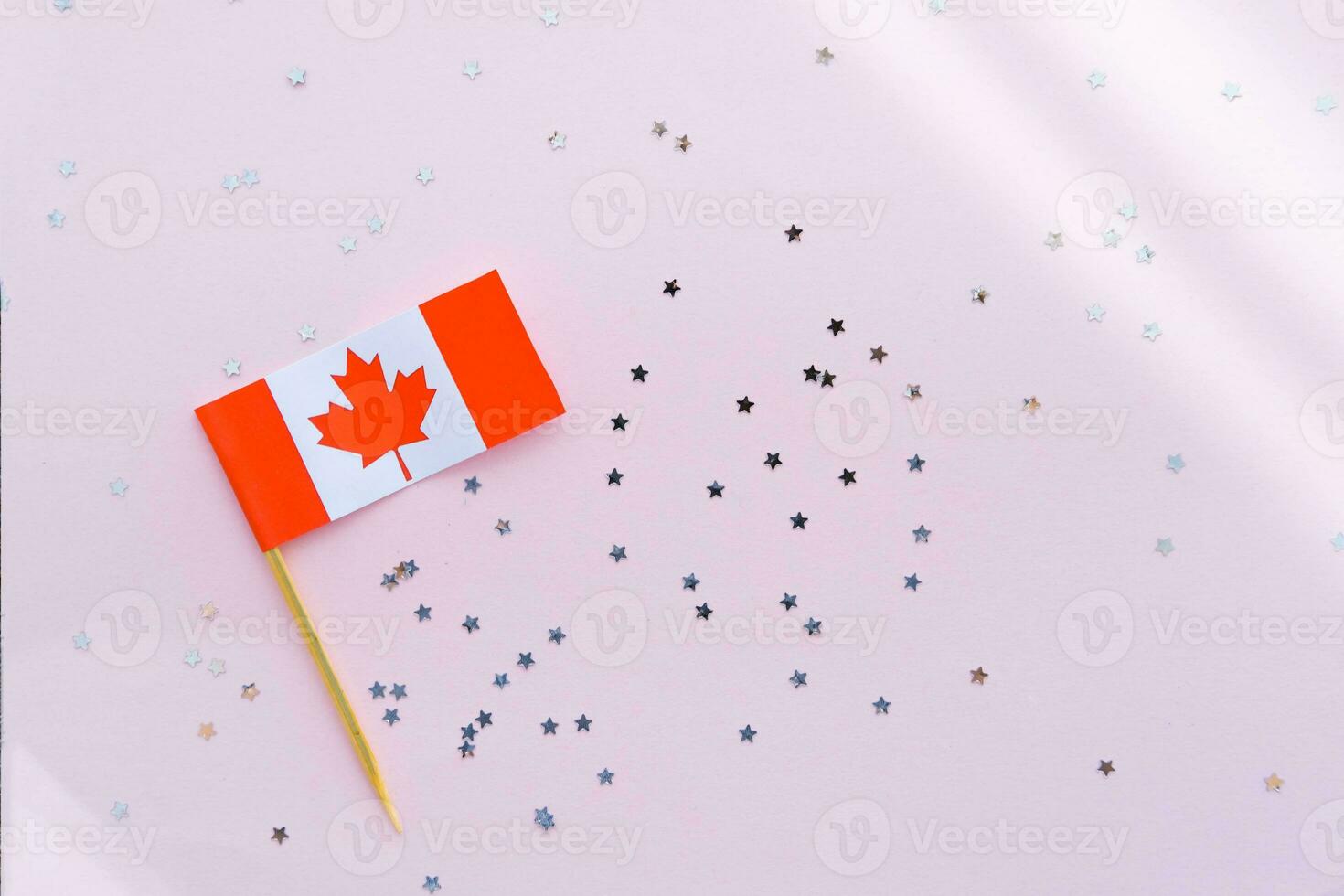 Canada flag and sparkles on pink background, flat lay. Holiday in Canada. 1th of July, Canada's Happy Independence Day. Copy space for text. photo