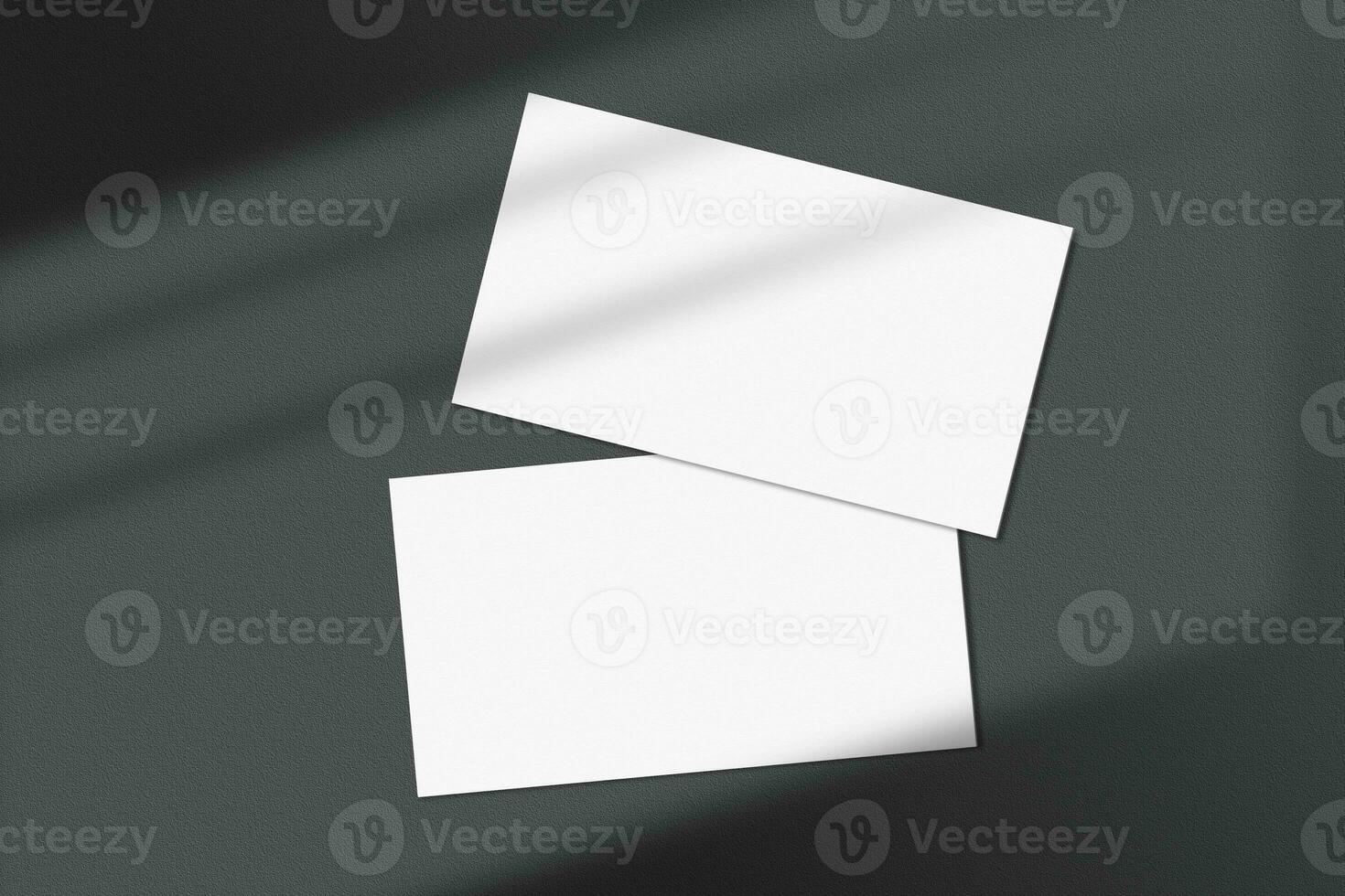 Realistic business card mockup flatlay. Simple two blank business cards on an elegant dark background top view. Two sides of business card mock up flat lay with shadow overlay effect photo