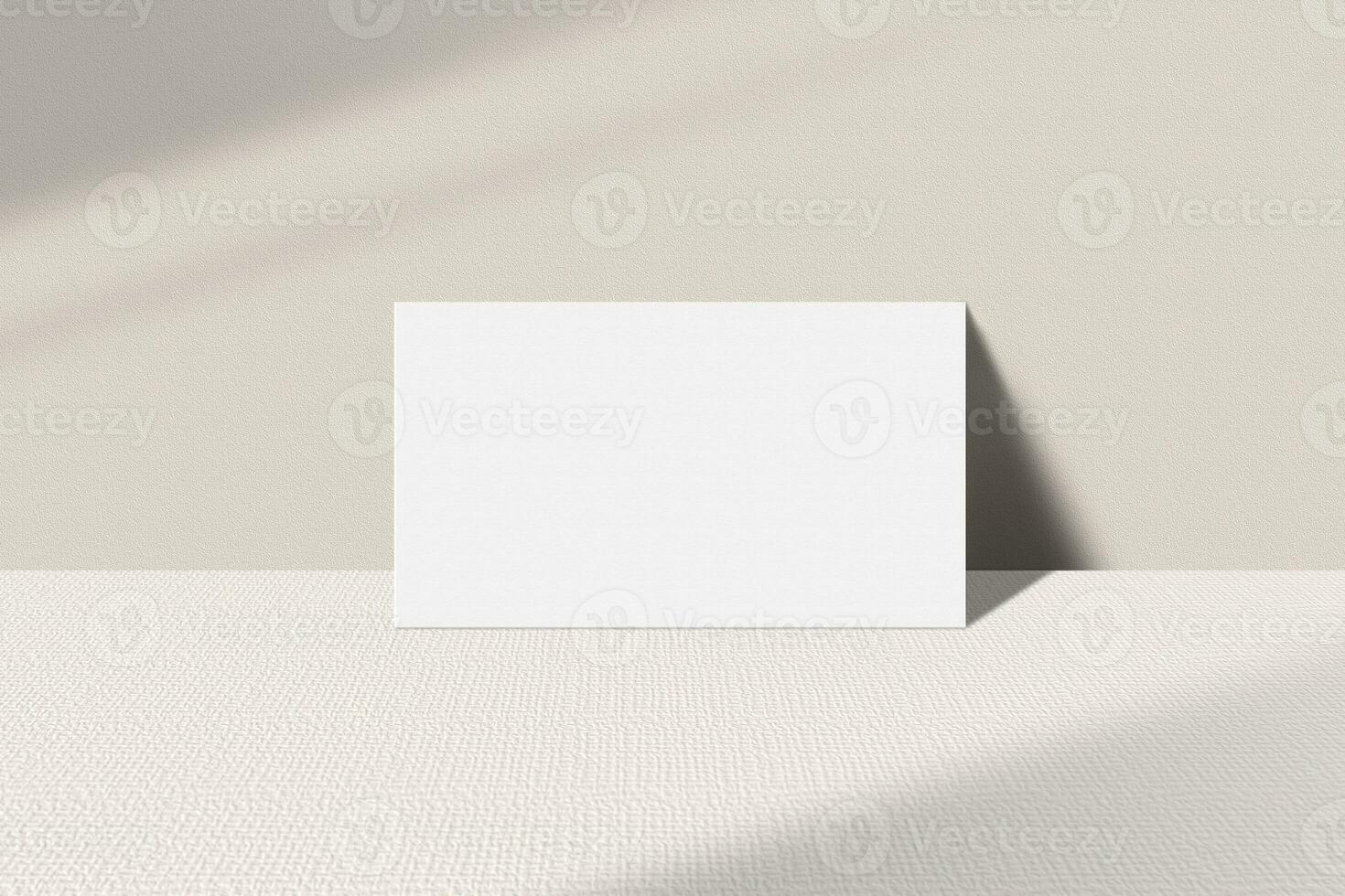 Realistic business card mockup leaning on the table. Simple blank business card on an elegant light background. Business card mock up with shadow overlay effect photo