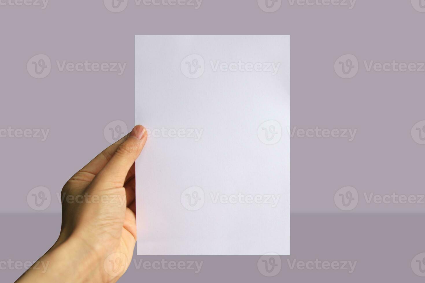 Realistic hand holding A5 paper mockup. Portrait A5 international paper size mockup. Simple, clean, modern, minimal paper mock up. Paper mockup in hand photo