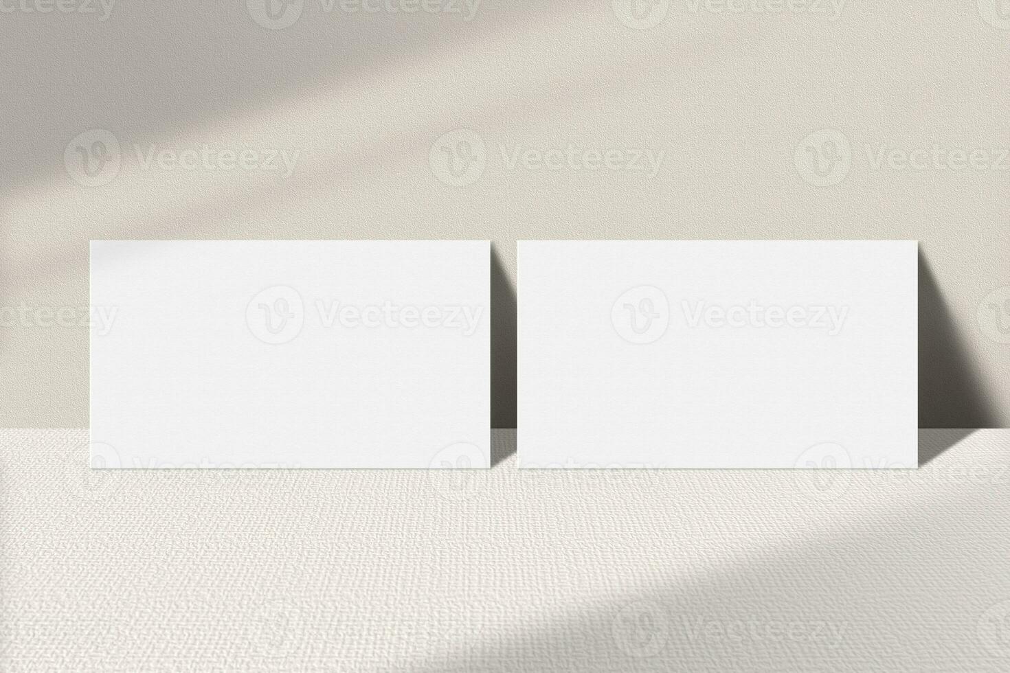 Realistic business card mockup leaning on the table. Simple two blank business cards on an elegant light background. Two sides of the business card mock up with shadow overlay effect photo