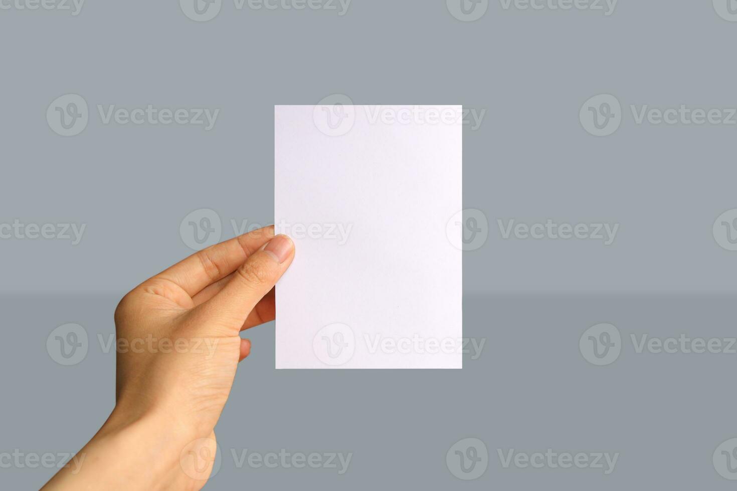 Realistic hand holding A6 paper mockup. Portrait A6 international paper size mockup. Simple, clean, modern, minimal paper mock up. Paper mockup in hand photo