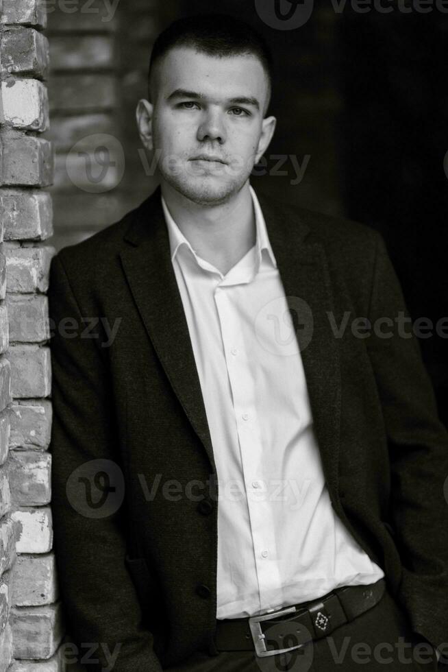 portrait of a young guy groom in a dark wool suit photo