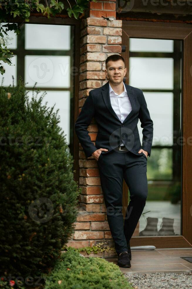 retrato de un joven chico novio en un oscuro lana traje foto