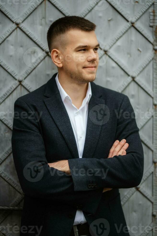 portrait of a young guy groom in a dark wool suit photo