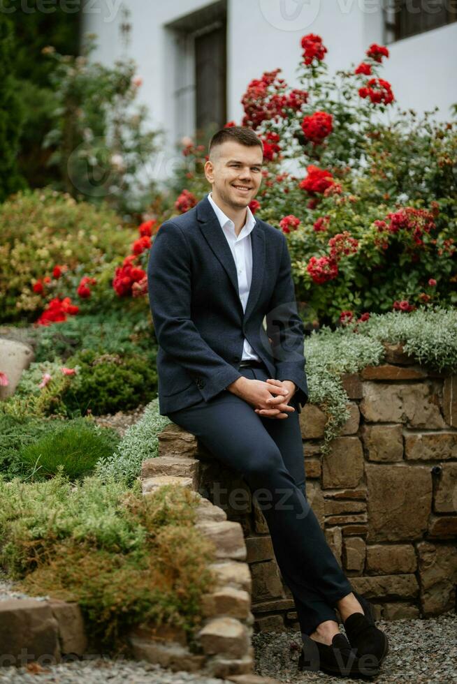 portrait of a young guy groom in a dark wool suit photo