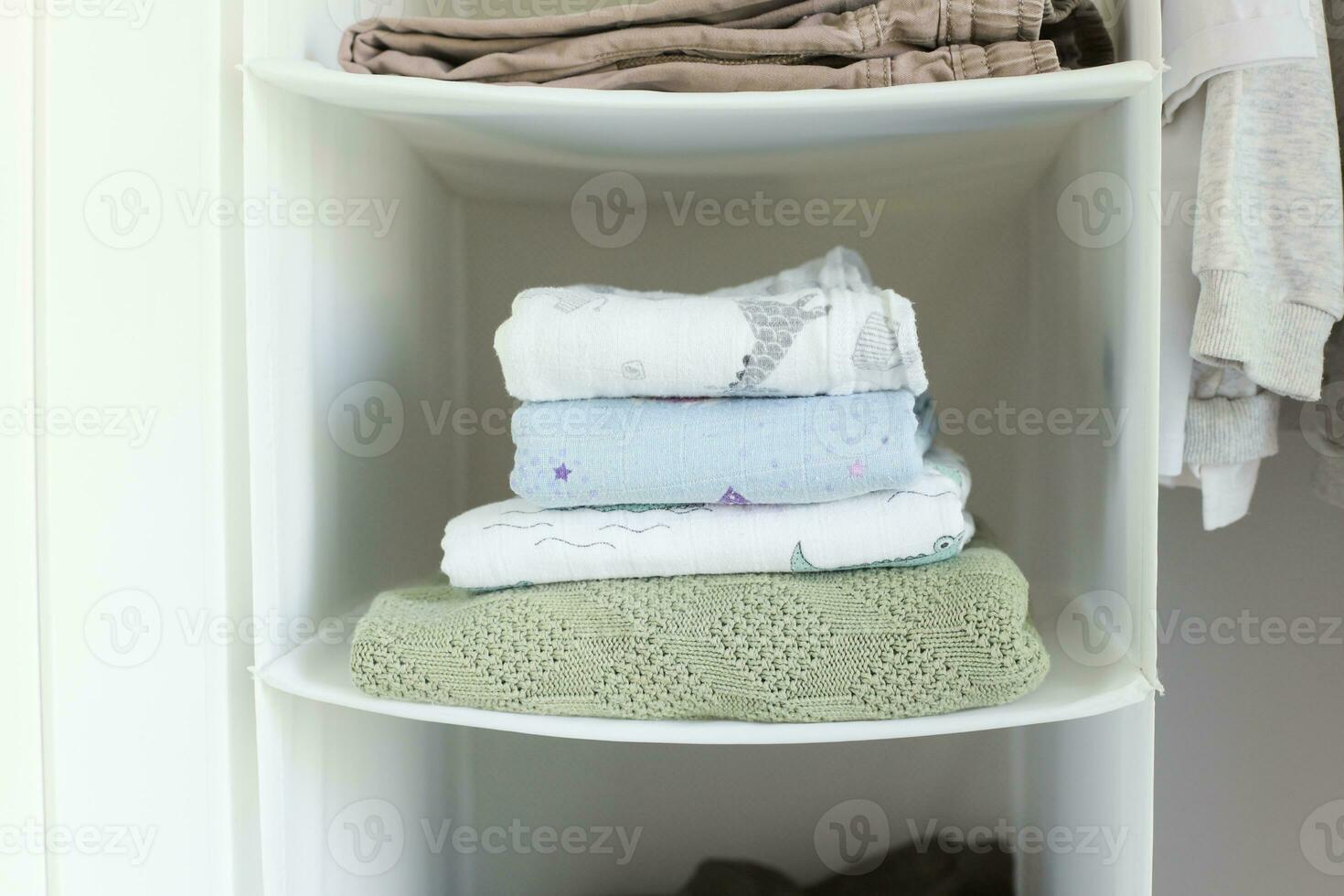 A stack of baby blanket. Muslin film. Knitted baby blanket photo
