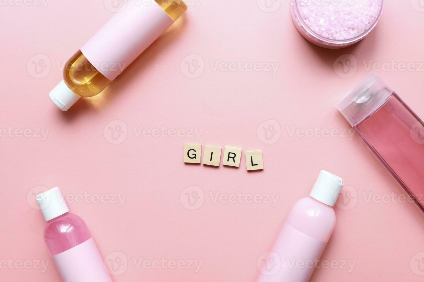 Flat lay word girl from wooden letters on a pink background. Bottles mockup. Spa jars. Girl care. beauty routine photo
