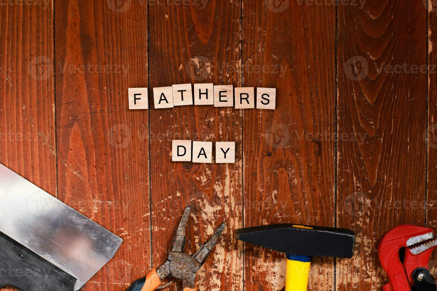 Flat lay happy father's day lined with letters. Building tools on a wooden background. Repair and construction photo