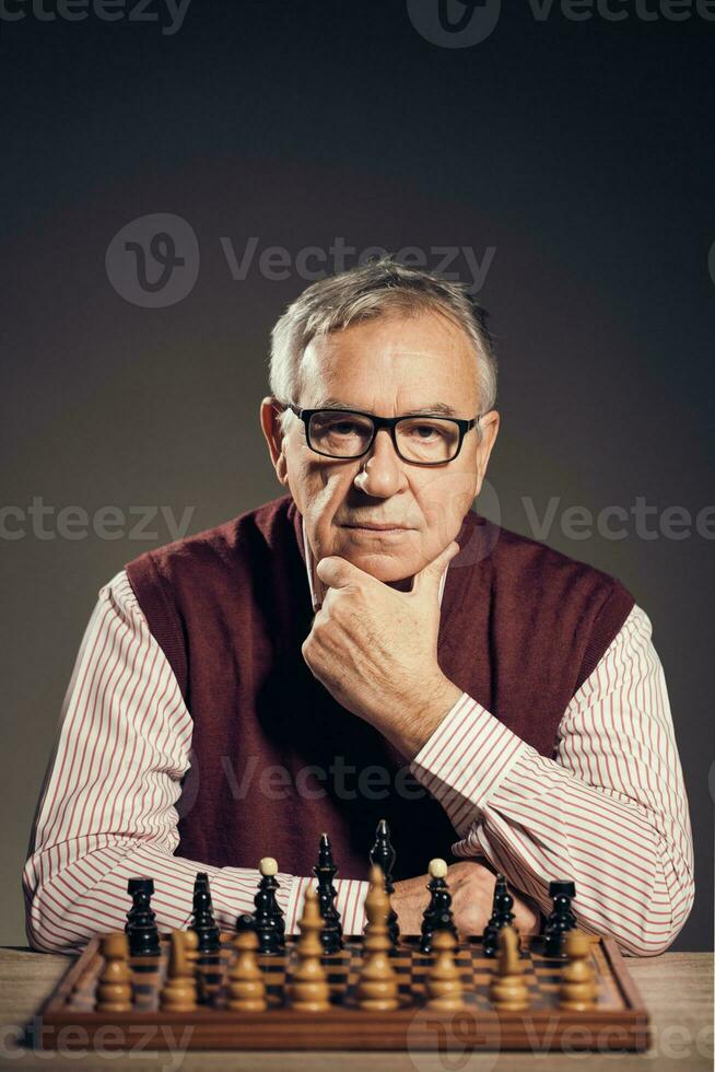 A senior man playing chess photo