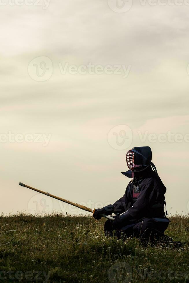 Silhouette of kendo fighter with shinai photo