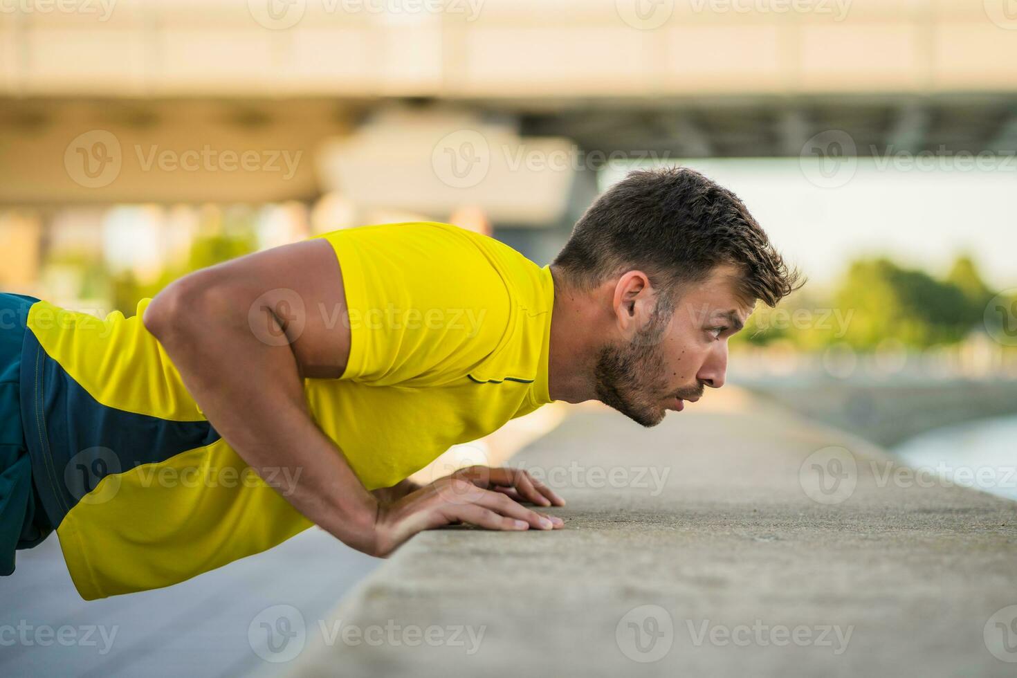 A man in a yellow t-shirt doing physical exercises photo