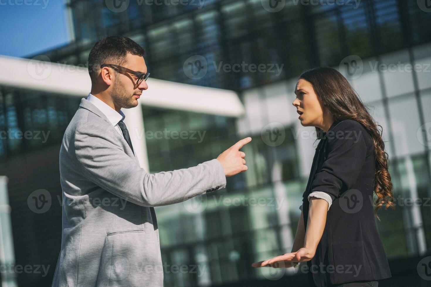 Business colleagues are arguing outside the company building. photo