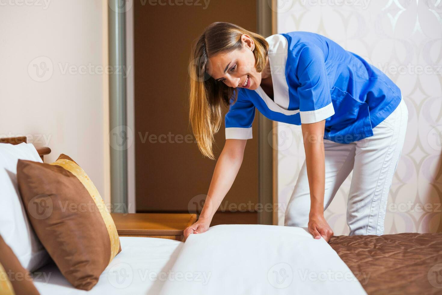 A maid working in a hotel room photo