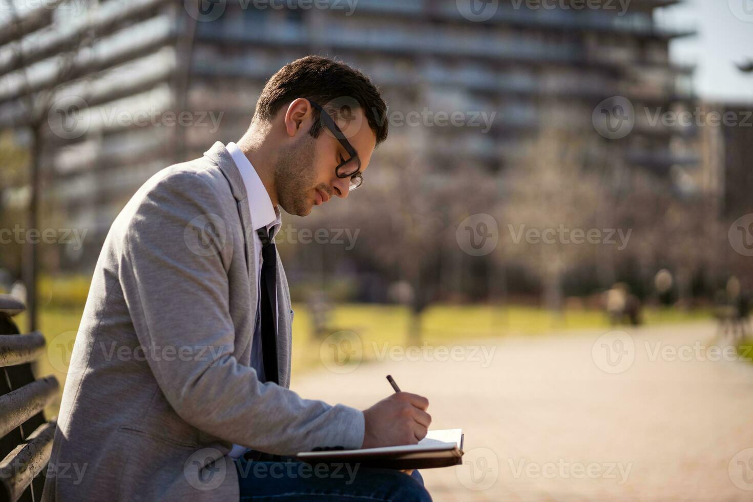 A businessman sitting on a park bench photo