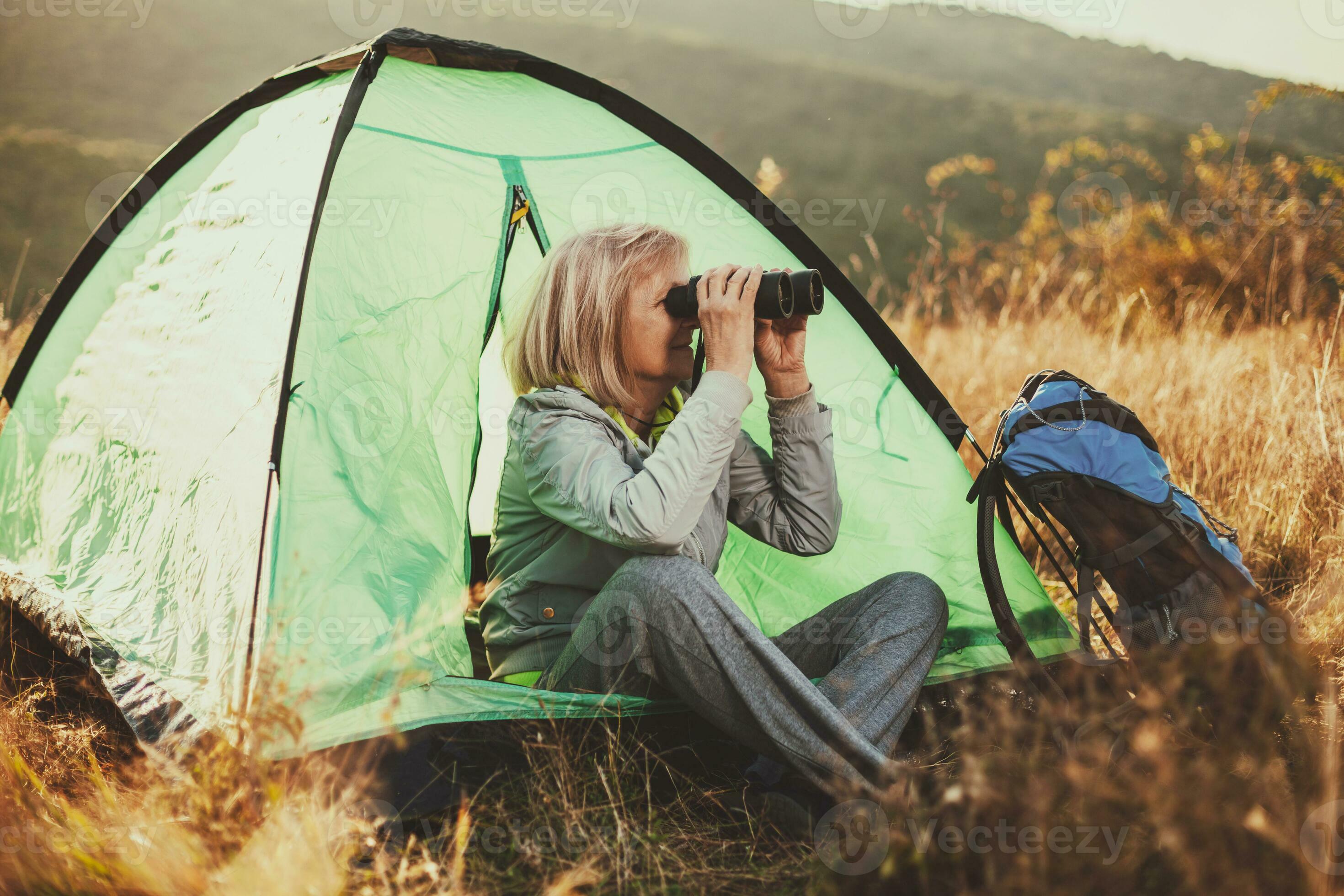 A senior woman camping 23908952 Stock Photo at Vecteezy