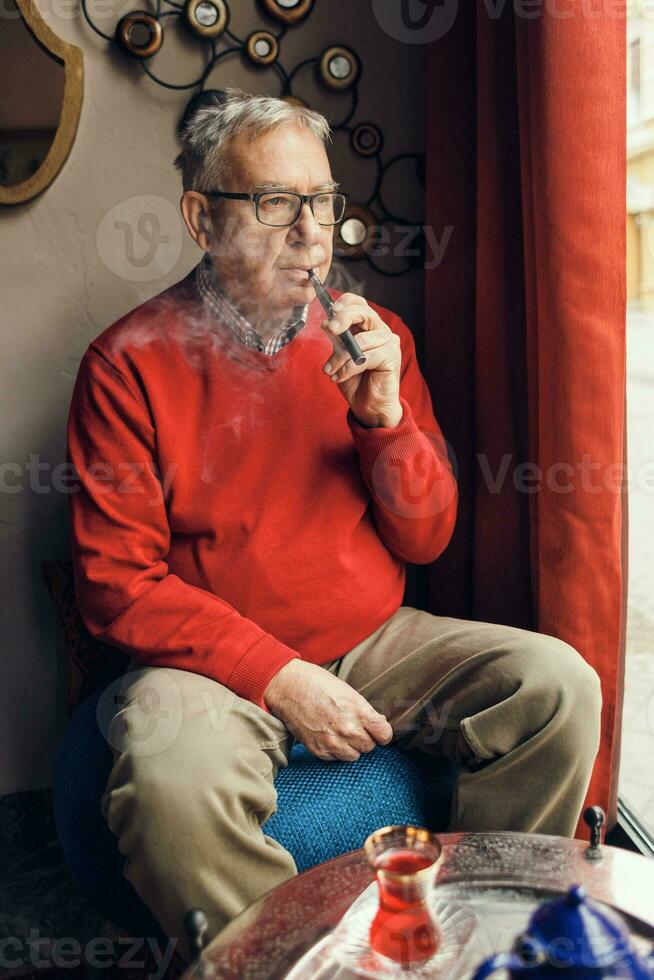 A senior man in a red sweater relaxing photo