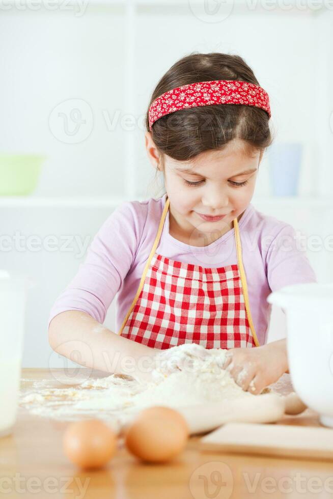 un joven niña Cocinando foto