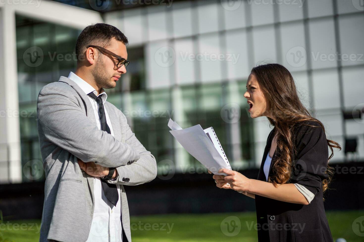 Business colleagues are arguing outside the company building. photo