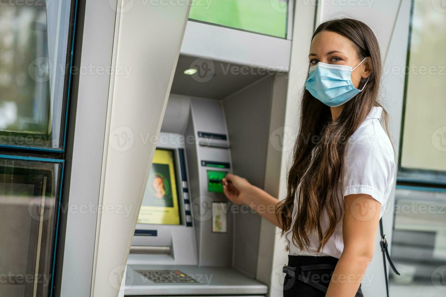 A woman using an ATM photo