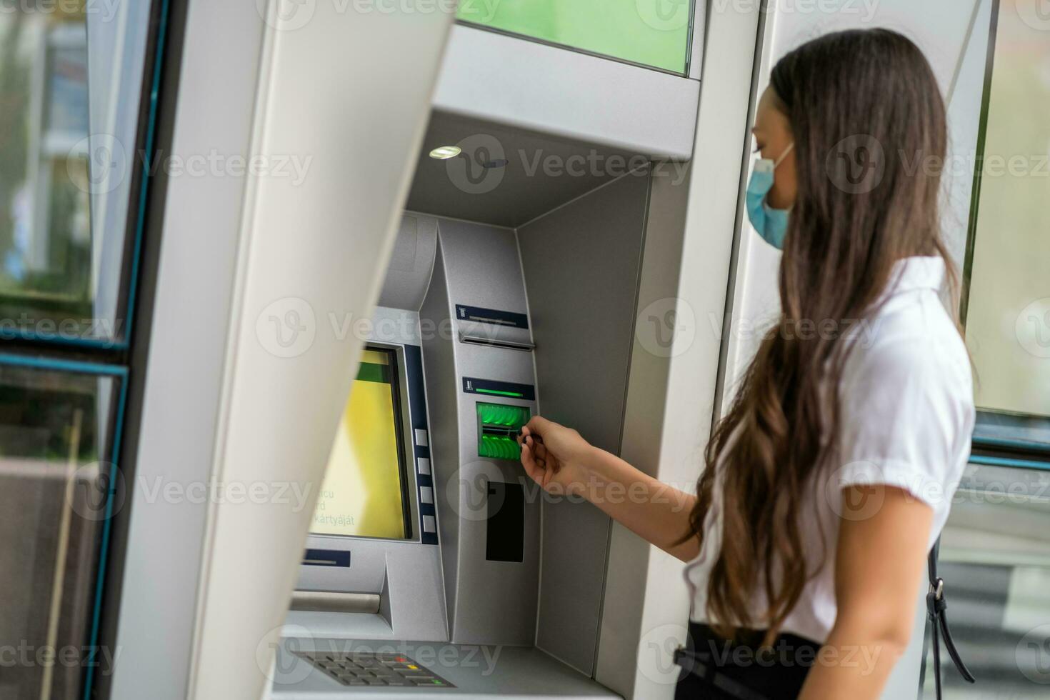A woman using an ATM photo