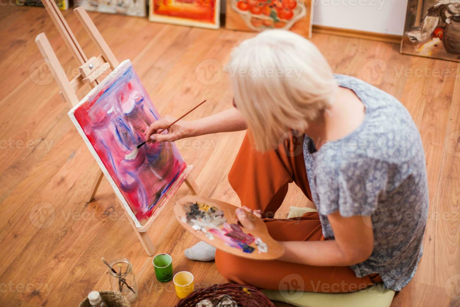 A senior woman painting photo