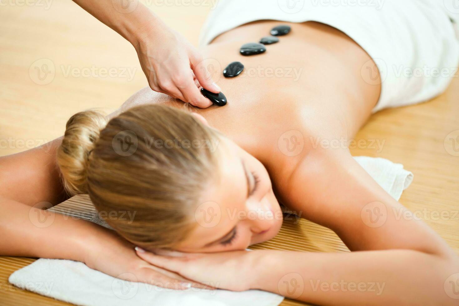 un mujer consiguiendo un caliente Roca masaje foto