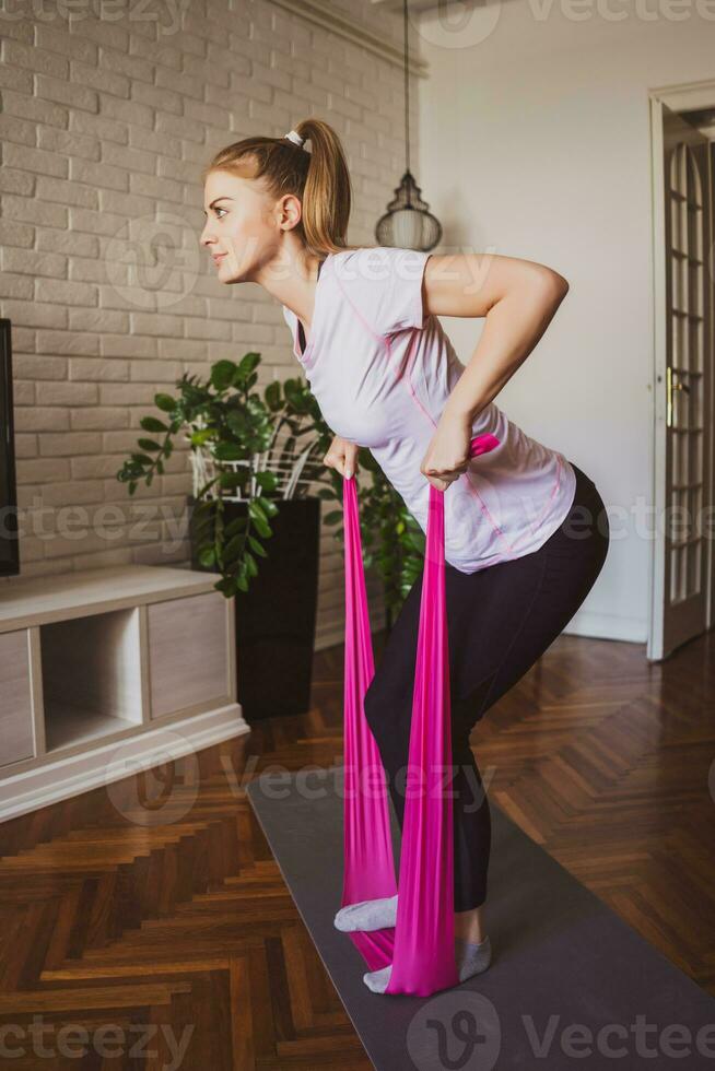 joven mujer haciendo físico ejercicios a hogar foto