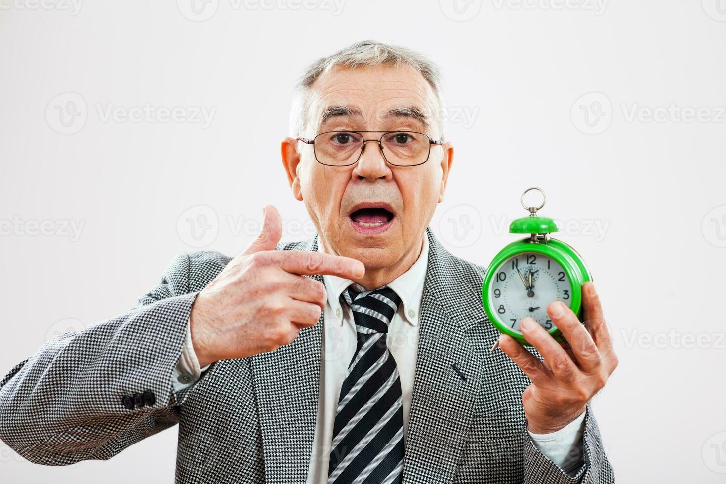 Portrait of a senior businessman with a clock photo