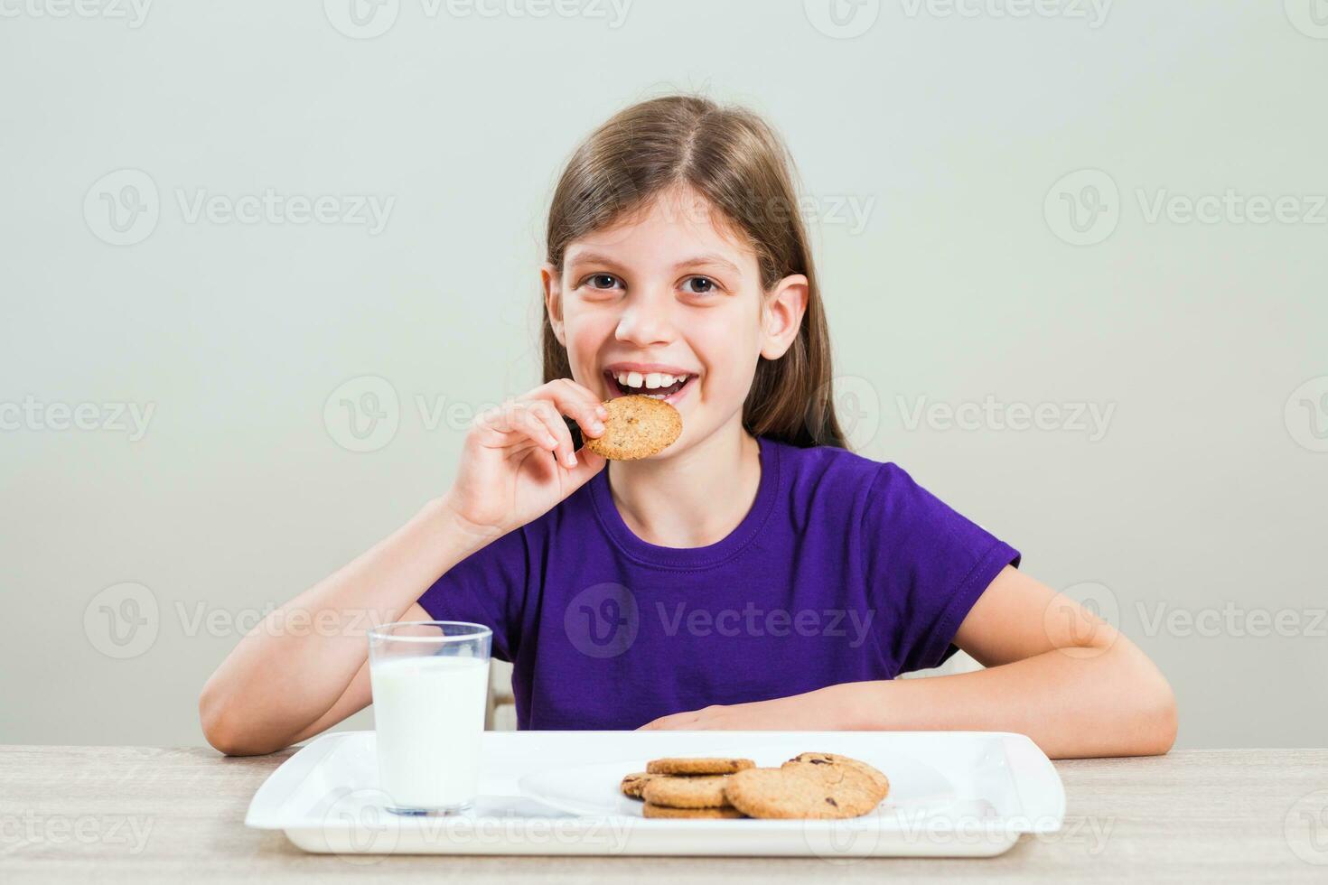 A girl eating cookies with milk photo