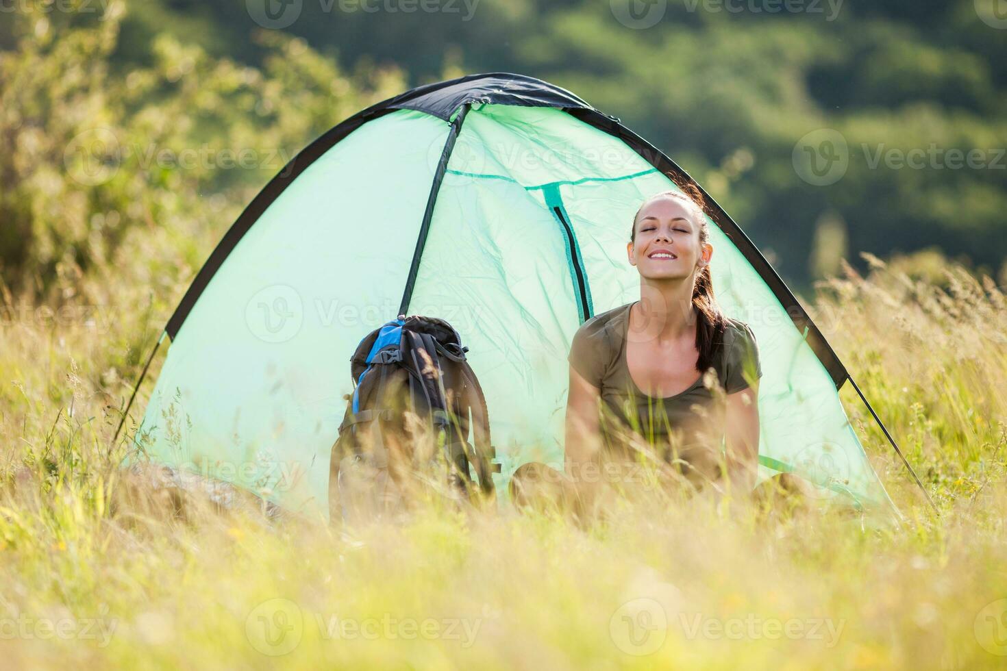 A woman camping alone in the wilderness photo