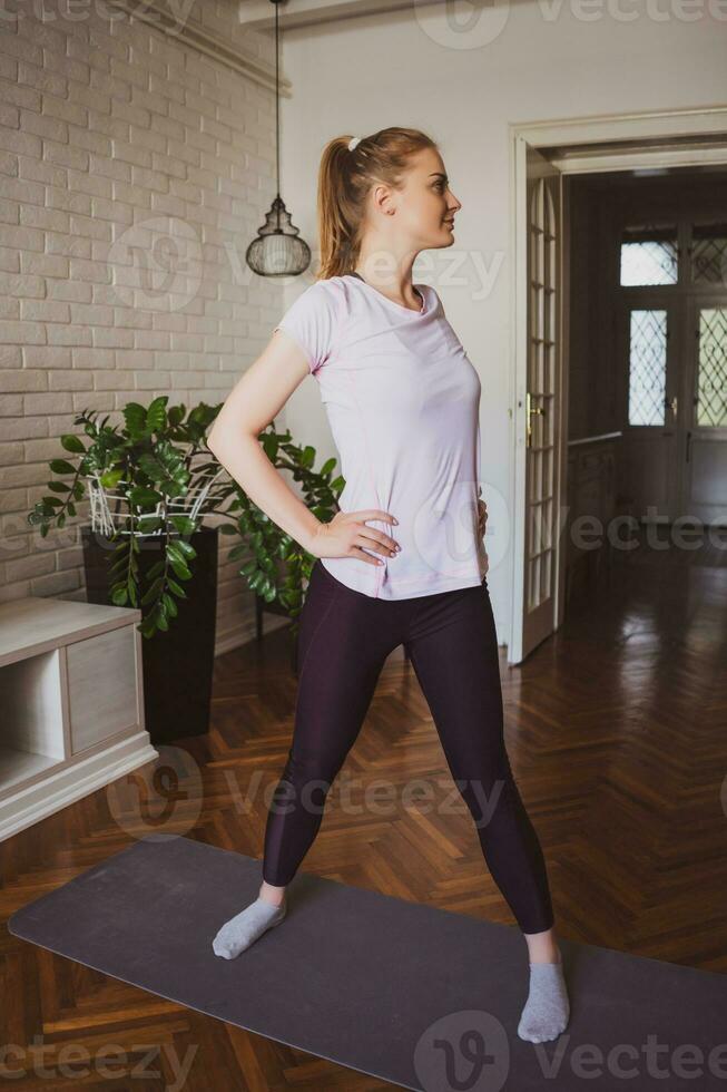 Young woman doing physical exercises at home photo