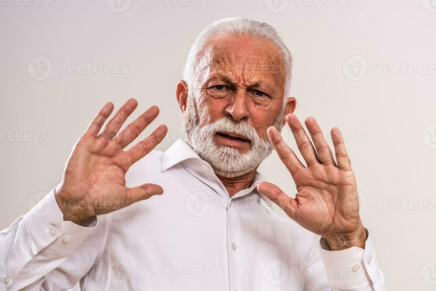 Portrait of a scared senior man in a white shirt photo