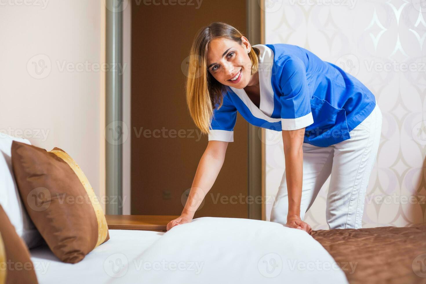 A maid working in a hotel room photo