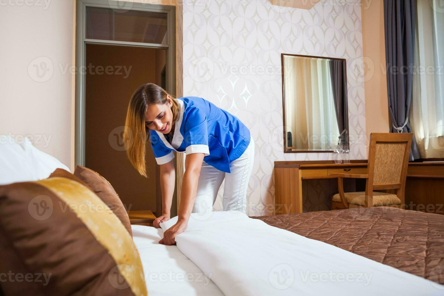 A maid working in a hotel room photo