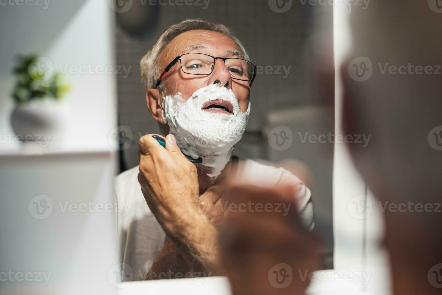 Senior man shaves his beard photo