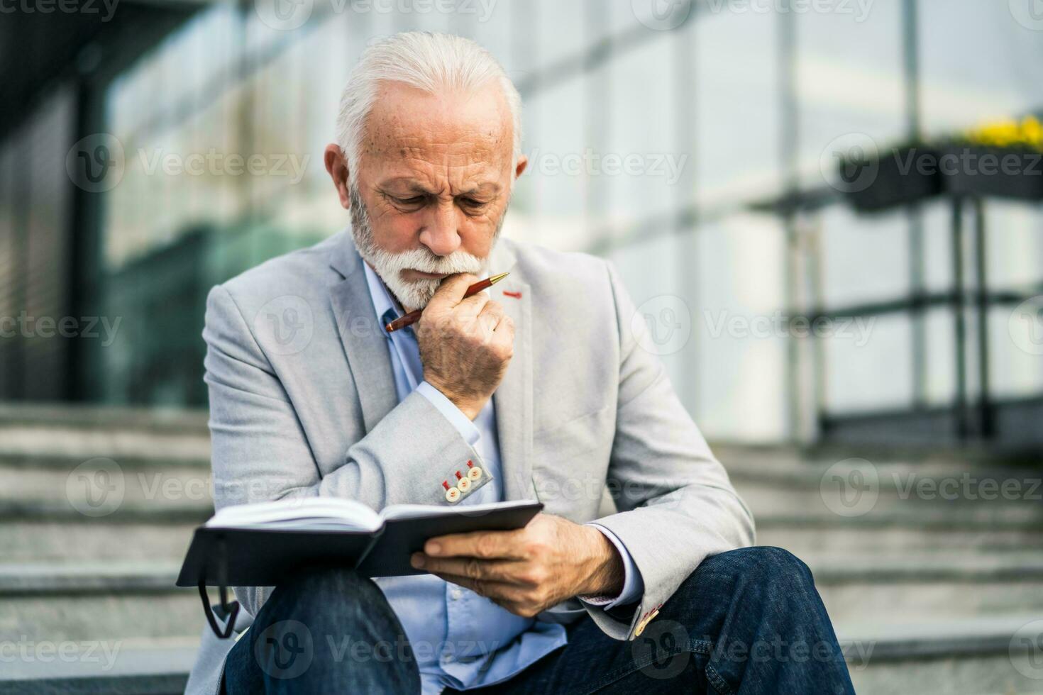 un estresado mayor empresario escritura en un cuaderno foto