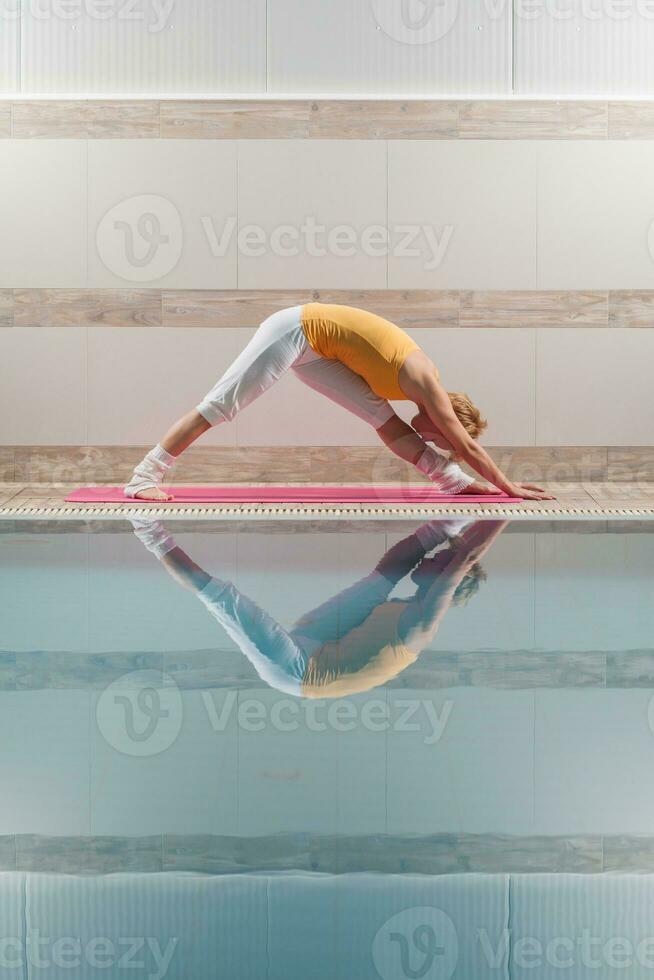 A woman doing physical exercises at the swimming pool photo