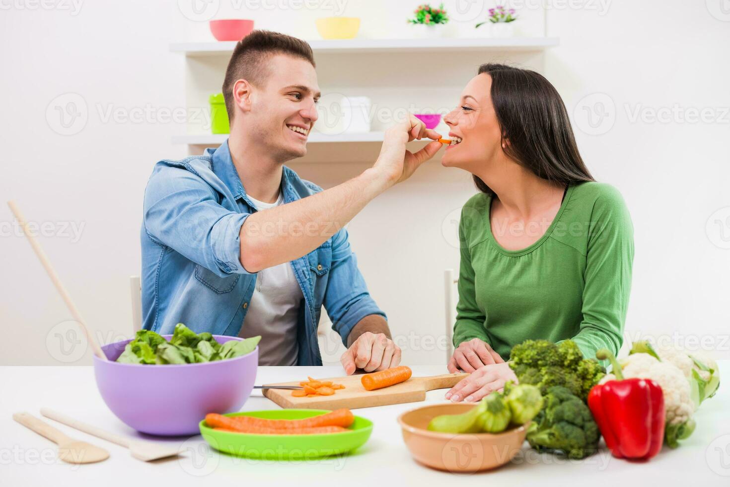 un Pareja teniendo divertido haciendo un ensalada foto