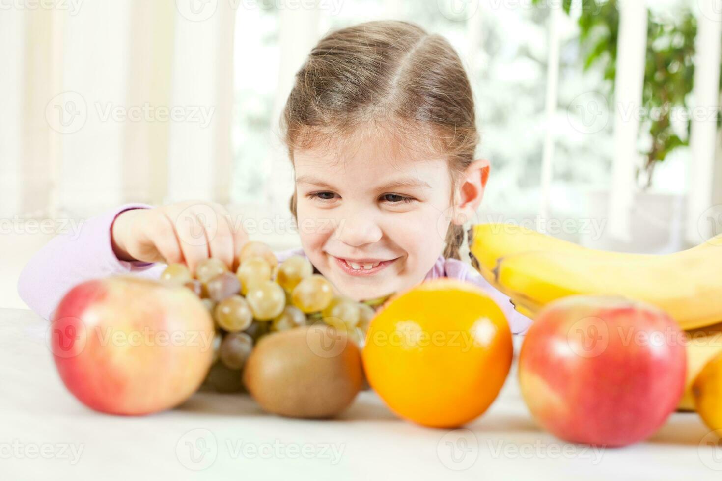 Little girl with fruits for health and wellness concept photo