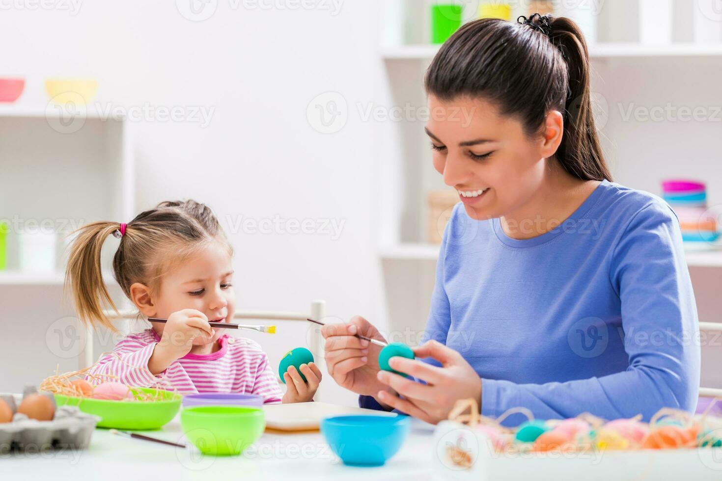 A mother and daughter painting eggs photo