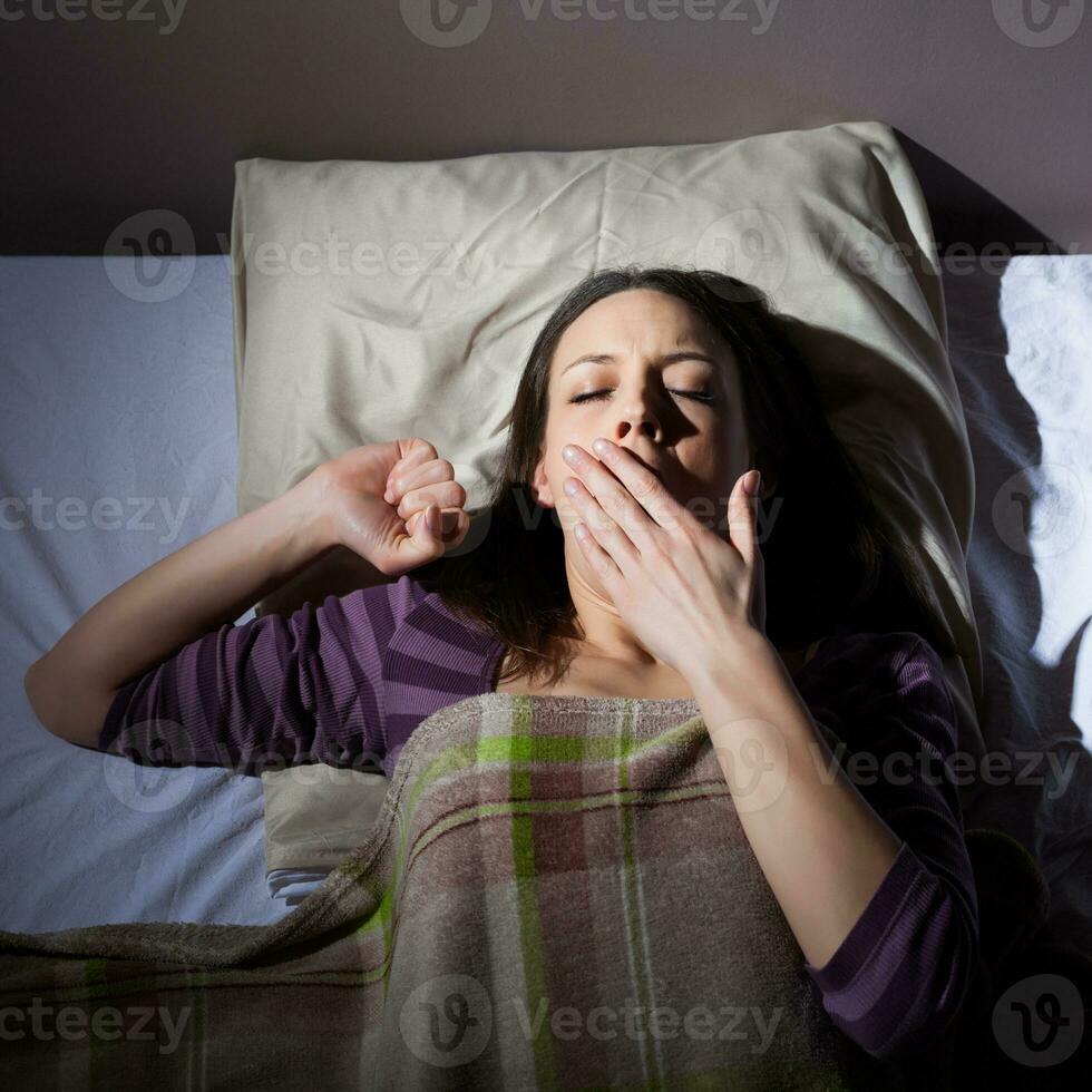 un joven mujer descansando en el cama foto